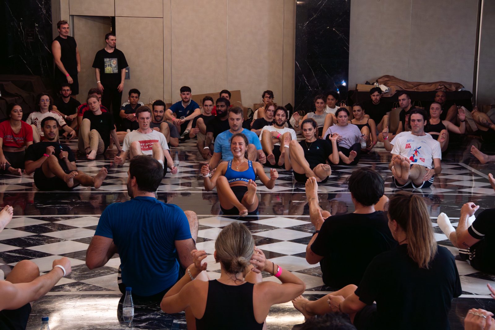 Group movement and stretching session on a checkered floor at a Casa Très wellness event