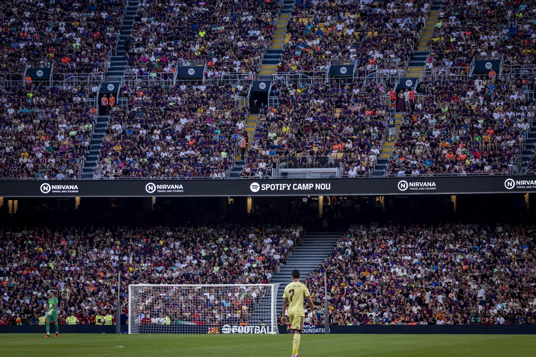 A Barça player on the pitch in front of packed stands at Spotify Camp Nou